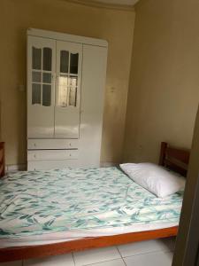 a bedroom with a large bed and a cabinet at Casa Edgar in Manaus