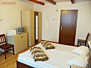 1 dormitorio con 1 cama con toallas en Pensiunea Valea Cernei, en Teliucu Inferior