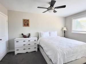 - une chambre avec un lit blanc et un ventilateur de plafond dans l'établissement Cozy Home in Niagara-on-the-Lake, à Niagara on the Lake