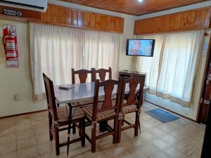 a dining room with a table and chairs and a television at La Casa de Las Flores Potrero de los Funes in Potrero de los Funes