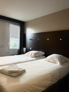 CarvinにあるParc Hôtelのベッドルーム1室(白いシーツが備わるベッド2台、窓付)