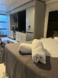 a hotel room with a bed with two white towels at An elegant stay away from home in Johannesburg