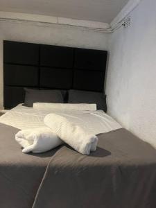 a bed with two white towels on top of it at An elegant stay away from home in Johannesburg