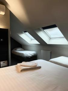 a bedroom with two beds and a skylight at Parc Hôtel in Carvin