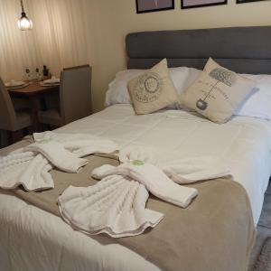 a bed with white towels and pillows on it at Pousada serrano in Monte Verde