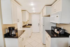 eine Küche mit weißen Schränken und einem weißen Kühlschrank in der Unterkunft Bright and Beautiful Dunes Room 1st Floor in Pawleys Island