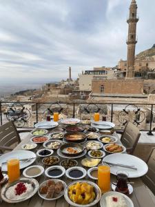 einen Tisch mit Teller mit Speisen über einer Stadt in der Unterkunft Gazi Konagi Butik Hotel in Mardin