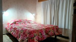 sypialnia z łóżkiem z czerwoną narzutą kwiatową w obiekcie La Casa de Las Flores Potrero de los Funes w mieście Potrero de los Funes