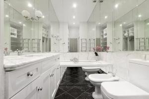 Baño blanco con 2 lavabos y 2 aseos en Renovu Premium Homes in Kensington, en Londres