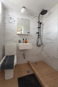 e bagno con servizi igienici, lavandino e doccia. di Moukas Seaside Apartments Romantico a Selianitika