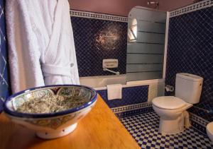 La salle de bains est pourvue de toilettes et d'un bol sur une table. dans l'établissement Riad Raouia HAMMAM & SPA, à Fès