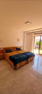 a large bed in a bedroom with a large window at Apartamentos Corea in Portonovo