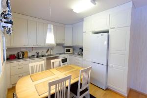 Rivitalokaksio 52m2 Sauna, Autokatospaikka, Pyykinpesukone, Ilmastointi في سينايوكي: مطبخ مع طاولة خشبية وثلاجة بيضاء +9 صور