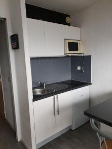 a small kitchen with a sink and a microwave at studio 4/5 couchages puy saint vincent 1600 in Puy-Saint-Vincent