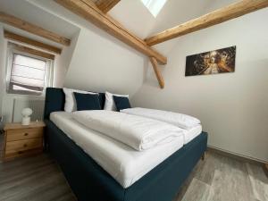 une chambre avec un lit avec des draps bleus et blancs dans l'établissement Ferienwohnung Hohensee 1.OG, à Clausthal-Zellerfeld