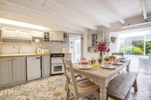 a kitchen with a wooden table with food on it at Tabbs Cottage - Close To Salcombe and Beaches in Malborough
