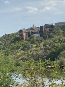 een groot huis bovenop een heuvel bij Reedbuck Lodge @Cyferfontein in Mabalingwe Reserve in Bela-Bela
