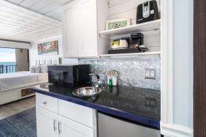 Una cocina con encimera y una cama en una habitación. en Lovely Oceanfront King Room 5th Flr, en Pawleys Island