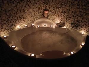 een badkamer met een bad met verlichting bij BORGO LORETO NAPLES in Napels