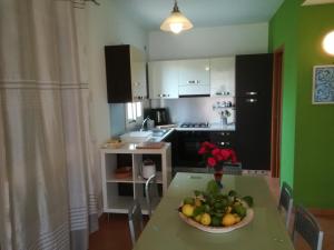 a kitchen with a table with a bowl of fruit on it at Villa Mimmo in Lascari