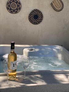a bottle of wine and two wine glasses in a bath tub at Le Clos de la Chèvre Sud in La Cadière-dʼAzur