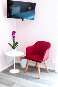 a red chair sitting next to a white table at Re Ottone Rooms in Lazise