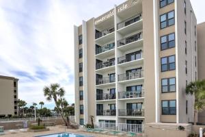 een appartementencomplex met een zwembad en palmbomen bij Emerald Isle Unit 211 in Fort Walton Beach