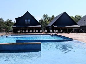 une grande piscine avec deux cabanes en arrière-plan dans l'établissement Moonlight View at Table Rock Lake, à Hollister