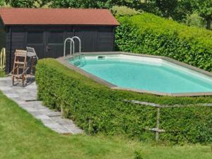 a swimming pool in a hedge next to a building at le Clos in Chambourg-sur-Indre