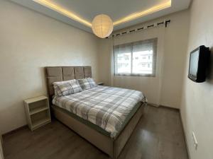 małą sypialnię z łóżkiem i telewizorem w obiekcie Grand Studio résidence neuve avec piscine w mieście Casablanca