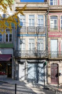 - un bâtiment avec balcon sur le côté d'une rue dans l'établissement Casa do Ofício - Livreiro, à Porto