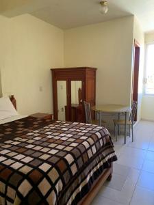 a bedroom with a bed and a table in it at Hotel Renacimiento in Comitán de Domínguez