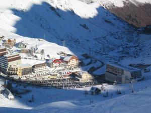 un complexe dans la neige sur une montagne dans l'établissement Appt La Mongie pied des pistes avec vues montagne, à Bagnères-de-Bigorre