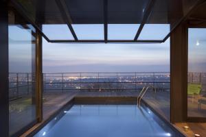 a swimming pool on the top of a building at L'Ermitage Hôtel Cuisine-À-Manger in Saint-Cyr-au-Mont-dʼOr