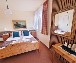 1 dormitorio con espejo grande y cama en Hotel Elisabeth Ilse en Braunlage
