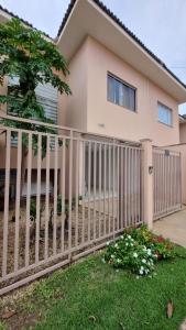a house with a white picket fence at Apartamento Confortável e Espaçoso in Sinop