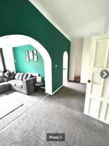a living room with a couch and a green wall at Quayside East 2 Bed in Heaton