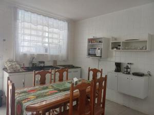 a kitchen with a table and chairs and a kitchen with a counter at #PARADISE SUITES - TATUAPÉ in Sao Paulo