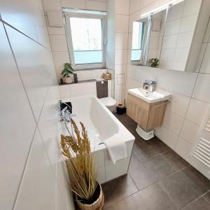 a bathroom with a tub and a toilet and a sink at Apartment am Hochwald in Reinhardtsdorf +19 photos
