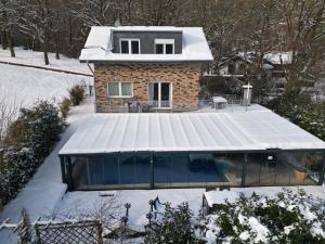 een huis met een zwembad in de sneeuw bij Wellness Apartments Sophienhöhe AM POOL in Mechernich