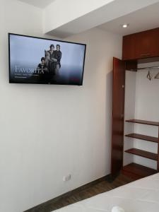a flat screen tv hanging on a wall in a bedroom at Casa Yuraq Hotel Boutique in Chincha Alta