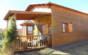 a wooden cabin with a porch and a deck at Carmeta - Casa Rural de madera con jardín, piscina privada y barbacoa - Deltavacaciones in L'Eucaliptus