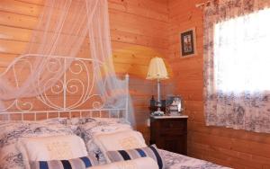 um quarto com uma cama num chalé de madeira em Carmeta - Casa Rural de madera con jardín, piscina privada y barbacoa - Deltavacaciones em L'Eucaliptus