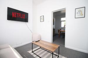 a room with a table and a sign on a wall at Bristol Street 2 BR FREE onsteet parking in Newport