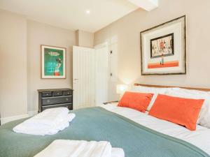 ein Schlafzimmer mit einem großen Bett mit orangefarbenen Kissen in der Unterkunft 1 Bed in Charmouth 87529 in Charmouth