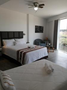 a bedroom with a large bed with a ceiling fan at Casa Yuraq Hotel Boutique in Chincha Alta