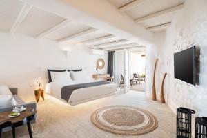 a hotel room with a bed and a tv at White Stone Mykonos in Agios Ioannis Mykonos