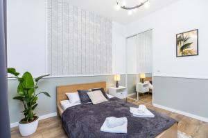 クラクフにあるNowoczesny apartament w ścisłym centrum Krakowaのベッドルーム1室(ベッド1台、タオル2枚付)