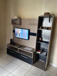 um centro de entretenimento com uma televisão de ecrã plano num quarto em Casa Edgar em Manaus