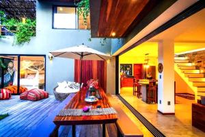 sala de estar con mesa y sombrilla en Casa'Lex, magnífica casa perto do mar, en Icaraí